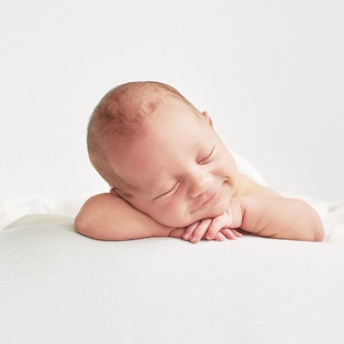 Cute newborn baby lies swaddled in a white blanket. Baby goods p